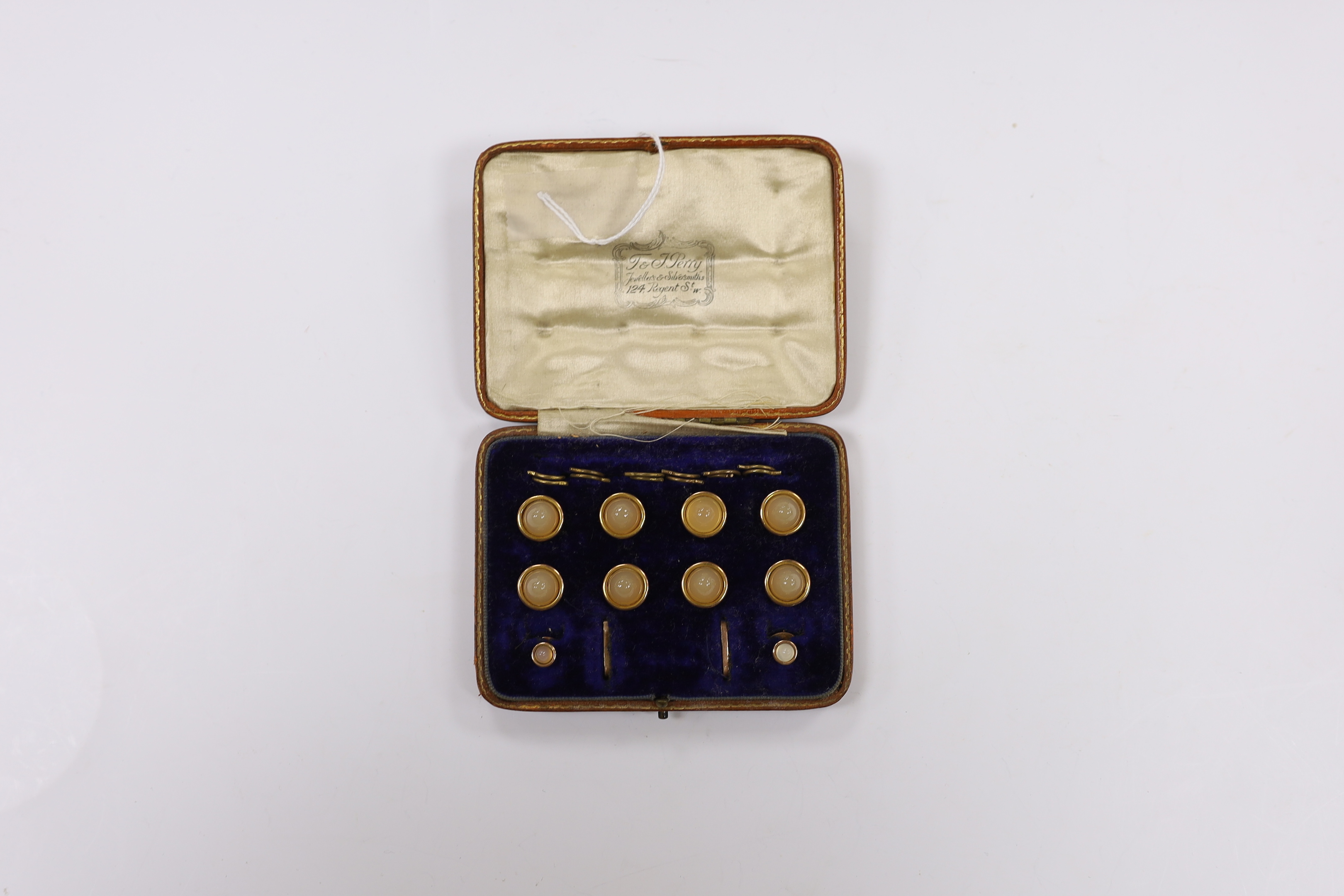 An early 20th century 9ct and chalcedony set ten piece dree stud set, in fitted gilt tooled leather case, gross weight 19.9 grams.